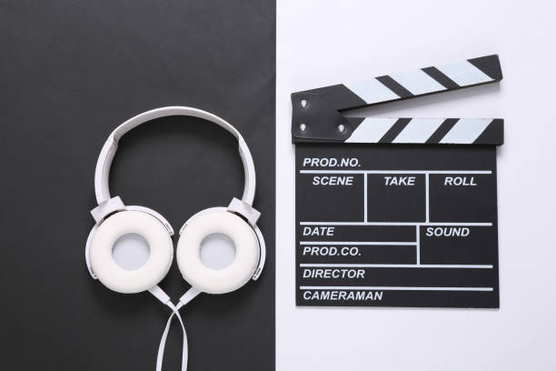 istock Clapperboard and headphones on white black background. Top view 1347497180