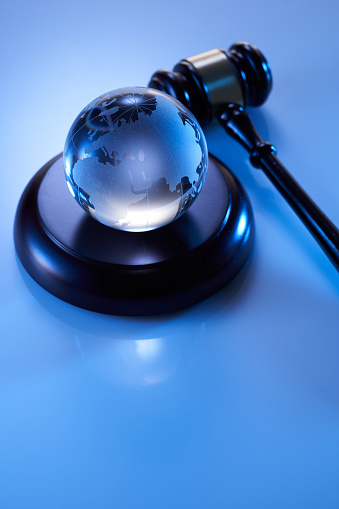Close-Up Of gavel hammer and glass globe on Asia and Africa against blue background
