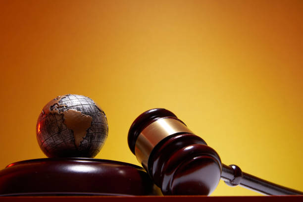 istock low angle view of gavel hammer and  globe against orange background 1347498646