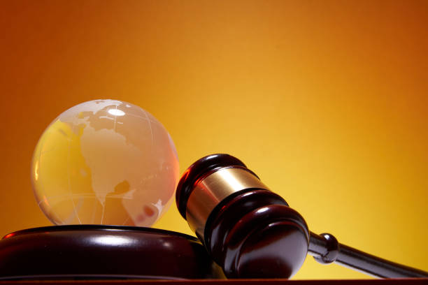 istock low angle view of gavel hammer and  globe against orange background 1347499484