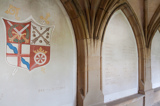 Coat of arms in arcade of church Essener Muenster with rows and timetables of people