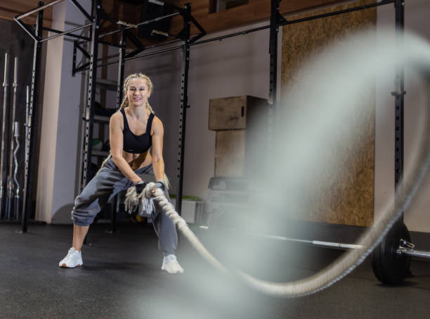 istock Athletic strong woman doing some exercises with battle rope in modern gym. Functional training 1347501582