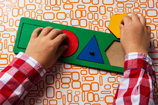 istock The child collects the sorter constructor. Puzzle sorter, an early development concept. Children's hands put the puzzle 1347501808