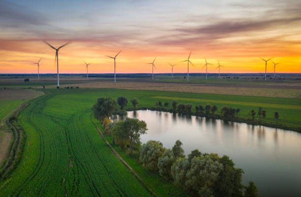 istock Amazing sunset over the field with wind turbines 1347503064
