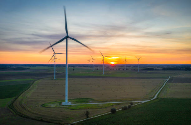 istock Amazing sunset over the field with wind turbines 1347503068