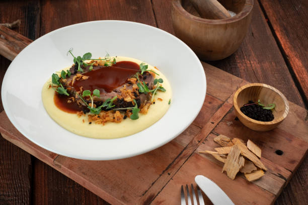 istock Roast beef with mashed potatoes with barbecue sauce on a plate on a wooden background 1347504001
