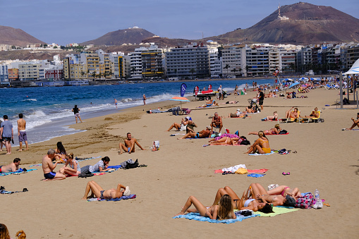 People sunbathe in Las Canteras beach on the island of Gran Canaria, Spain on October 6, 2021.