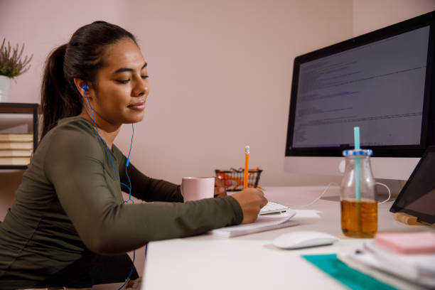 istock Diligent female university student sitting at her desk and writing homework 1347505196