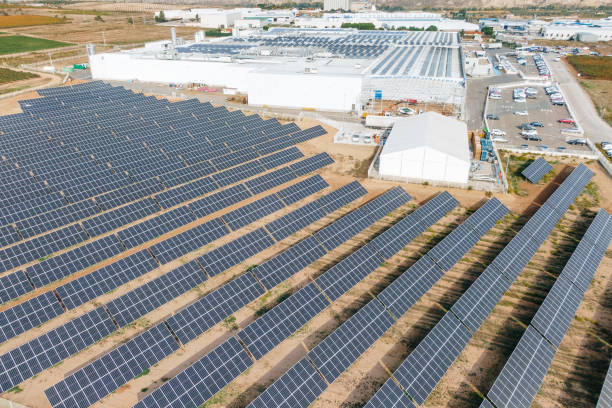 istock Solar energy farm next to industrial buildings 1347508943