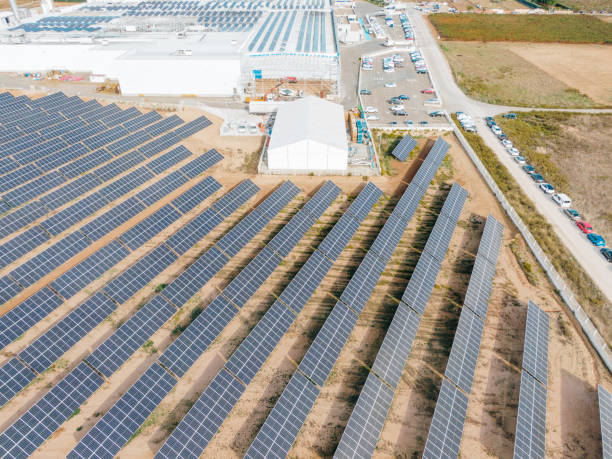 istock Solar energy farm next to industrial buildings 1347508975