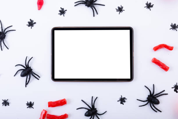 istock Composition of halloween spiders and sweets and tablet with copy space on white background 1347509233