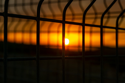beautiful sunset seen through the iron fence