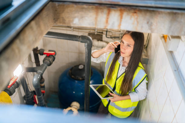 Female maintenance worker checking and fixing pipes and water pumping machines