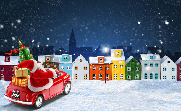 Christmas greeting card. Santa Claus driving red car with gift boxes and Christmas tree in the night christmas city Christmas 2022 greeting card. Santa Claus in red car delivering gift boxes and Christmas tree in the night snowy city with Colorful miniature houses arranged in a row. christmas card photos stock pictures, royalty-free photos & images