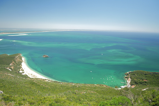 Green and blue water, hill forest and Sandy beach