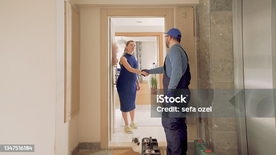 istock Repairman Handshake in House Door 1347516184