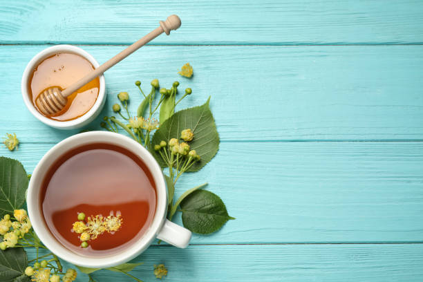 istock Flat lay composition with tea and linden blossom on light blue wooden table. Space for text 1347516202