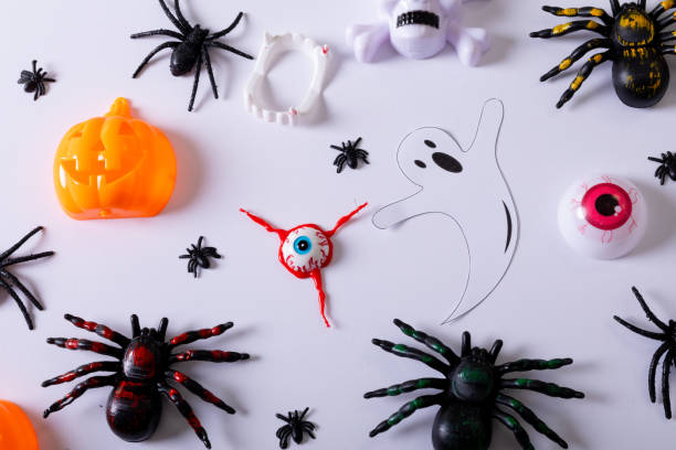 istock Composition of halloween decorations with spiders, ghost and pumpkin on white background 1347516286