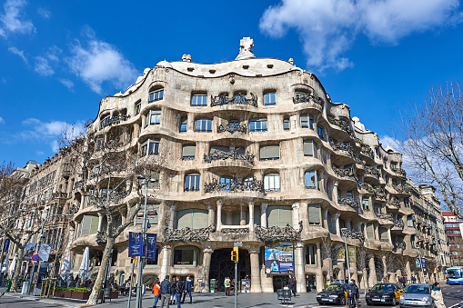 Barcelona, Spain - February 24, 2013: Low angle view of Casa Mila at sunny day, Barcelona, Spain. Casa Mila is the private residence designed by Antonio Gaudi.
