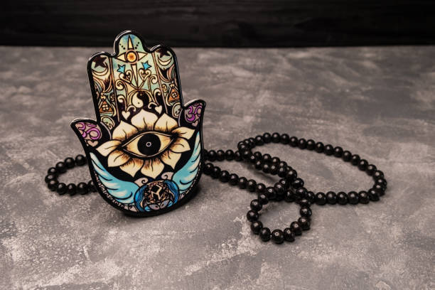 decoration piece of a palm with an eye in it, called hamsa hand. - evil eye beads imagens e fotografias de stock