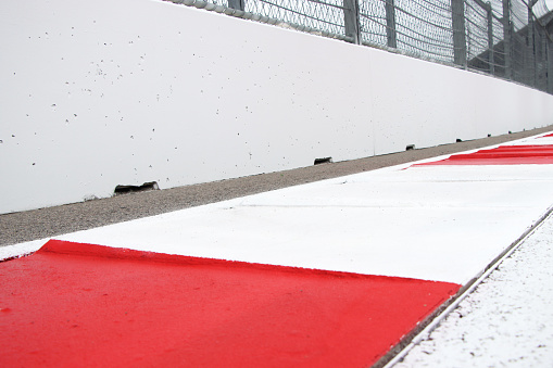 Elements of the racing track: red and white kerb, white wall with space for your text