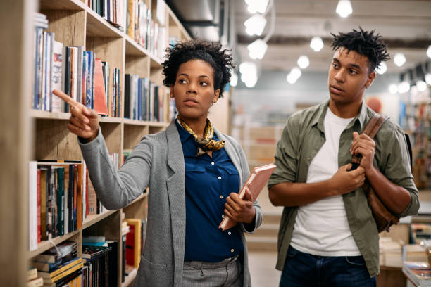 you can find books for your research on this shelf! - librarian imagens e fotografias de stock