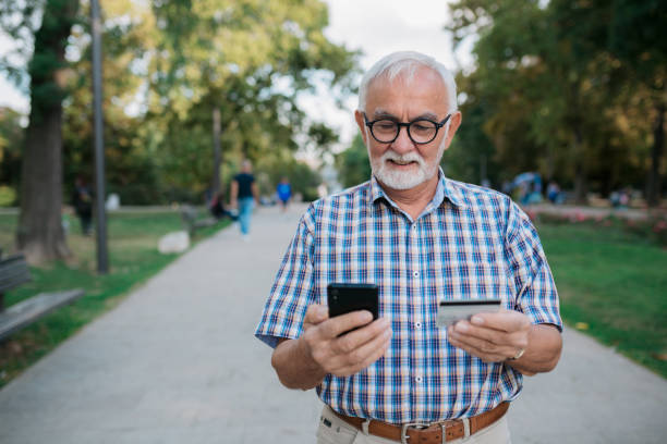 istock Senior Caucasian man using a credit card and a smart phone 1347521667