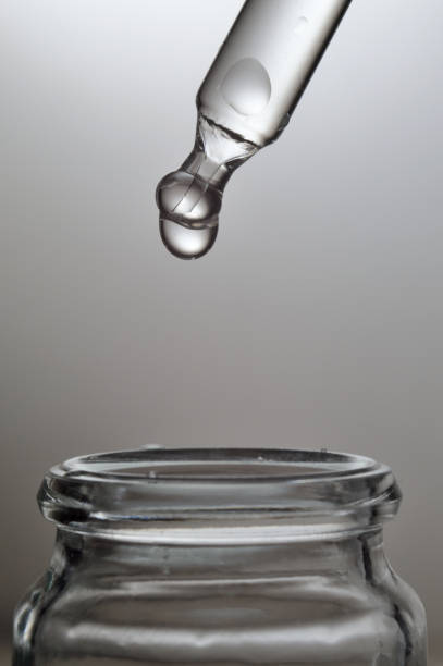istock Liquid transparent gel or serum pipette with drops on gray background 1347525127