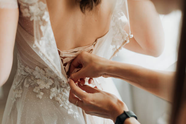 istock young bride is helped to put on a white wedding dress 1347525912