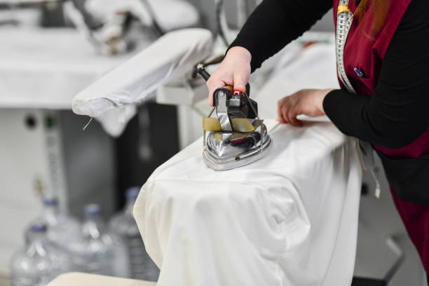 istock Female Textile Worker Ironing Clothes In Factory 1347526376