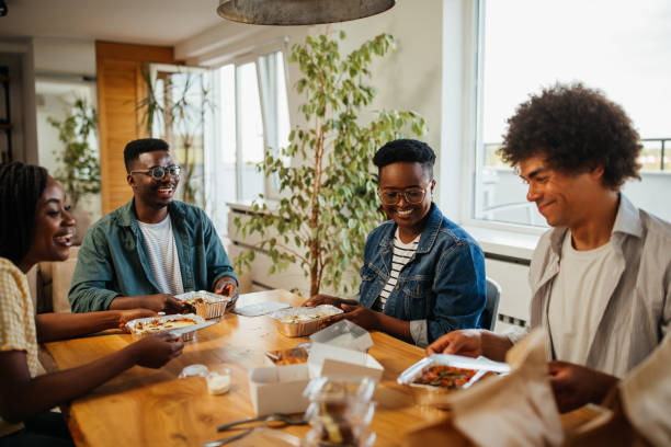 istock Young happy friends having fun during lunchtime at home 1347527708