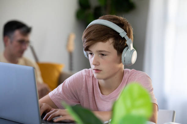istock Preteen Boy doing schoolwork on laptop from home 1347529044