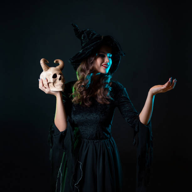 istock A young beautiful witch in a conical hat holds a devil's skull in her hands 1347529374