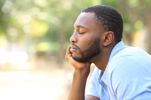 istock Man with black skin relaxing and resting in a park 1347531096