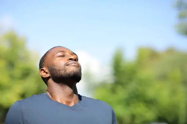 Man with black skin breathing in nature