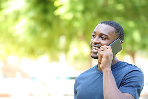 Happy man with black skin talking on phone