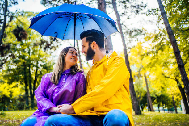 istock Couple on the bench at rainy autumn park 1347532594