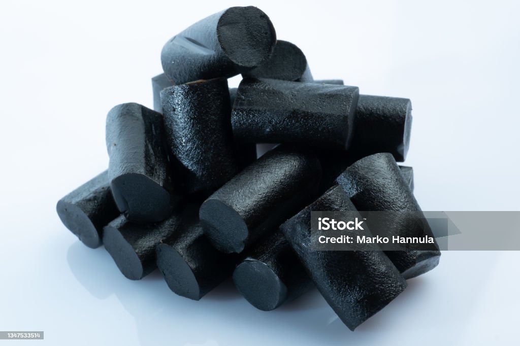 Closeup of a bunch of Finnish black licorice against bright white background Helsinki / Finland - OCTOBER 19, 2021: Closeup of a bunch of Finnish black liquorish against bright white background Licorice Stock Photo