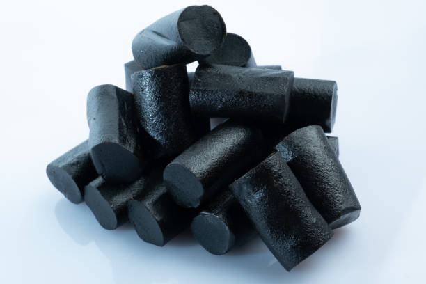 Closeup of a bunch of Finnish black licorice against bright white background stock photo