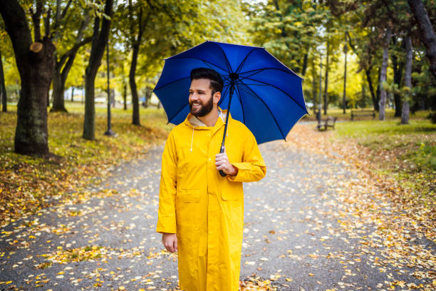 istock Smiling man with blue umbrella 1347533831