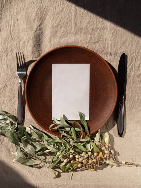 istock Empty craft handmade clay plate with fork knife on tablecloth. Table place hand crafted dish Natural home interior decor 1347535315