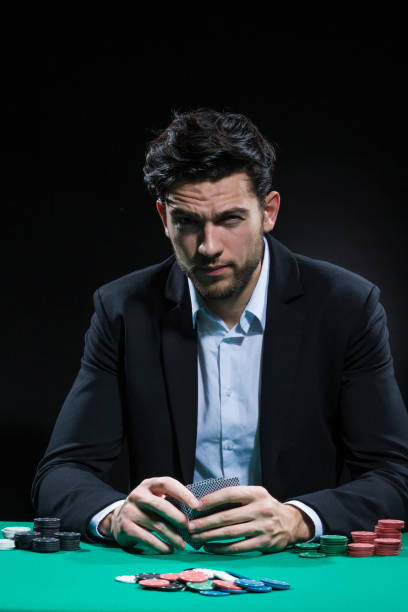 istock Serious Caucasian Young Handsome Pocker Player Staking and Betting To Win At Pocker Table With Chips And Cards. Vertical image 1347536760