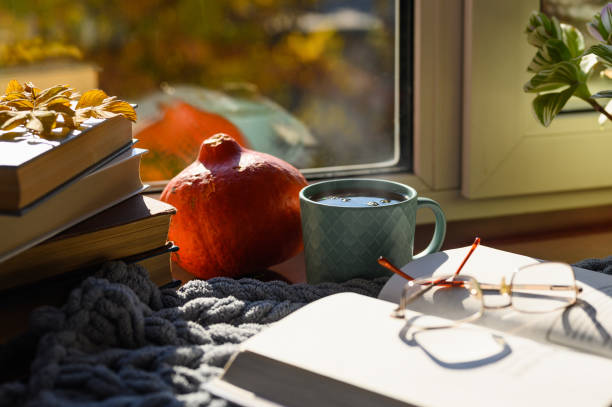 istock Hot tea by the window with books. Selective focus on a mug of tea 1347538272