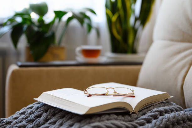istock Open book with glasses on a woolen blanket. 1347538275