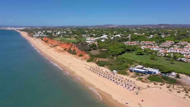 Aerial drone footage, shooting the tourist village of Vale de Lobo, on the shores of the Atlantic Ocean, golf courses for tourists. Portugal, Algarve.