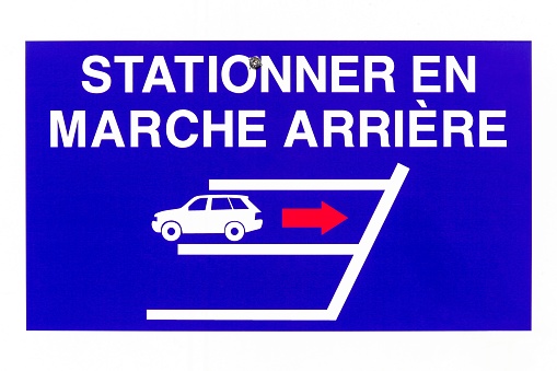 Reverse parking only sign on a wall called stationner en marche arriere in french language