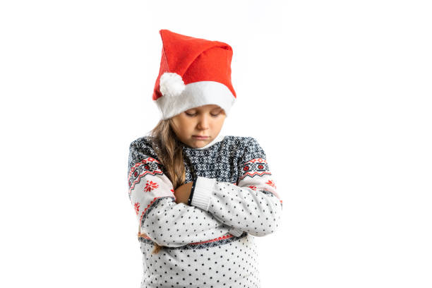portrait of sad, offended, disappointed girl in white knitted christmas sweater with reindeer, isolated on white background - santa hat bildbanksfoton och bilder