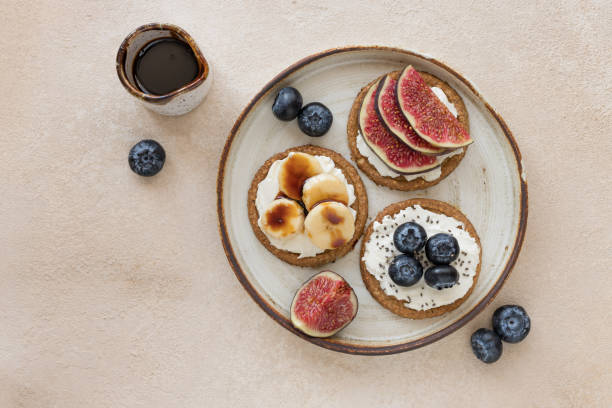istock Oat crispbread with different toppings and date syrup on ceramic plate 1347543365
