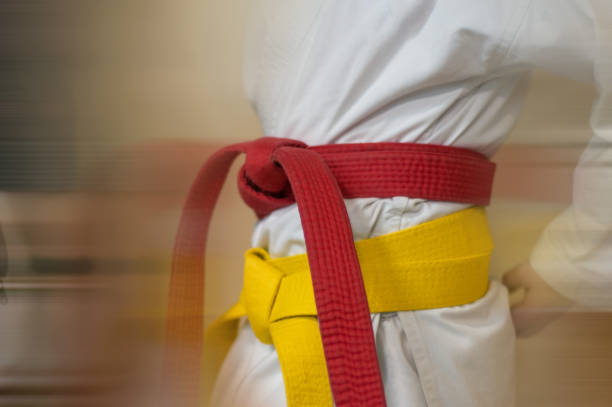 Red and white belts on a white kimano Red and white belts on a white kimano. A young fighter before going to a karate fight. yellow belt stock pictures, royalty-free photos & images