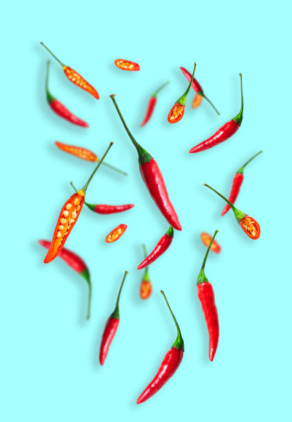 istock Hot chili peppers and chilli pieces levitating on light blue background 1347546513